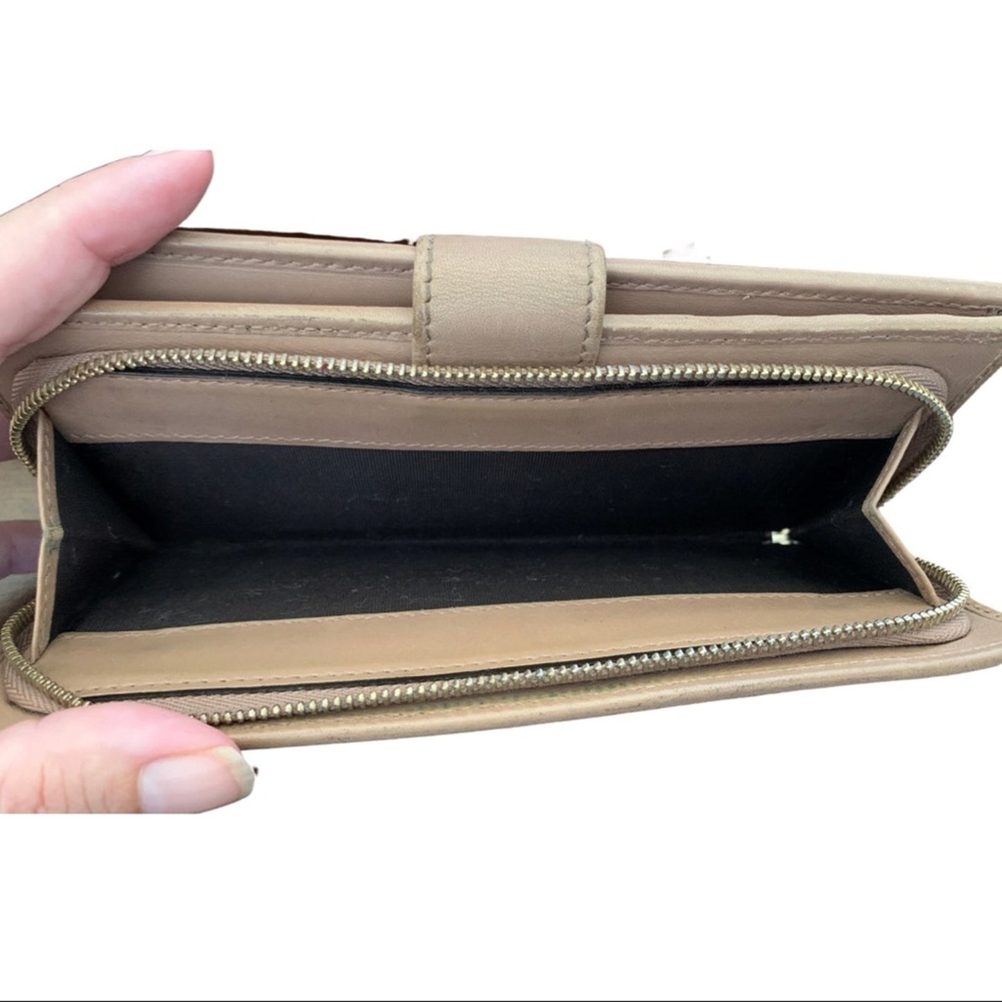 Pink wallet with a hand holding it open on a white background