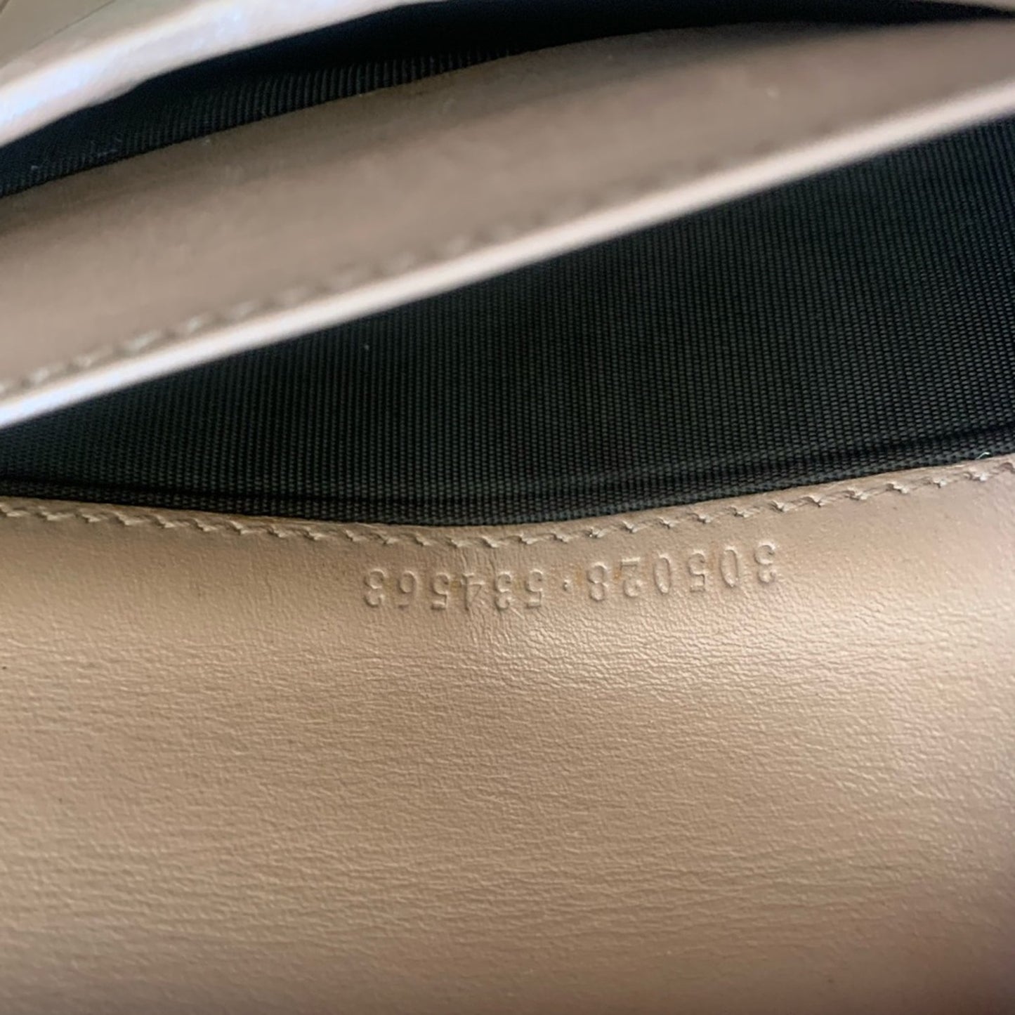 Close-up of a pink leather bag with serial number