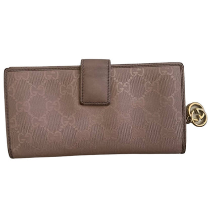 Pink GG Gucci wallet with gold detail on a white background