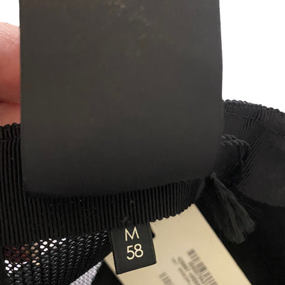 Close-up of a black garment with a size tag displaying  sizing 'M 58'.