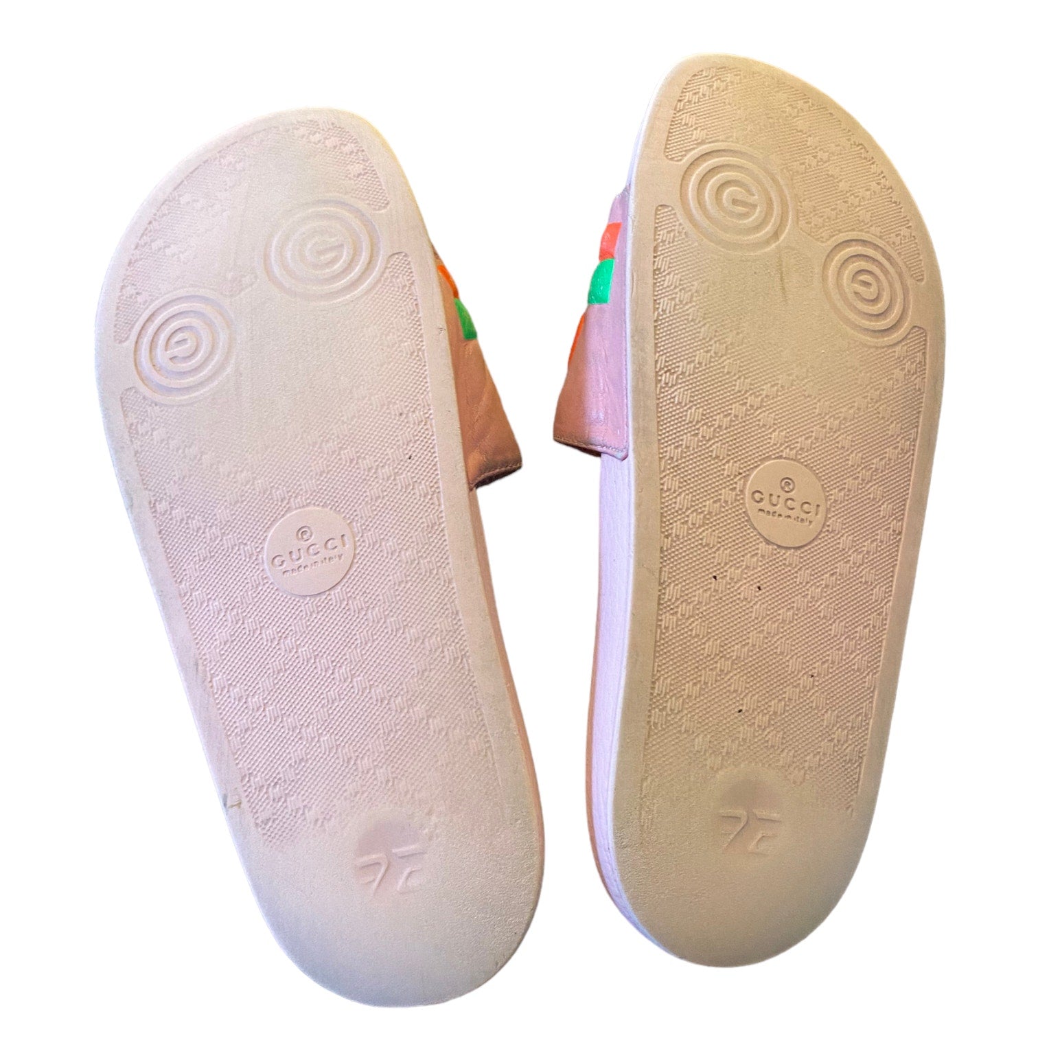 Gucci sandals with pink bottom of shoes on a white background