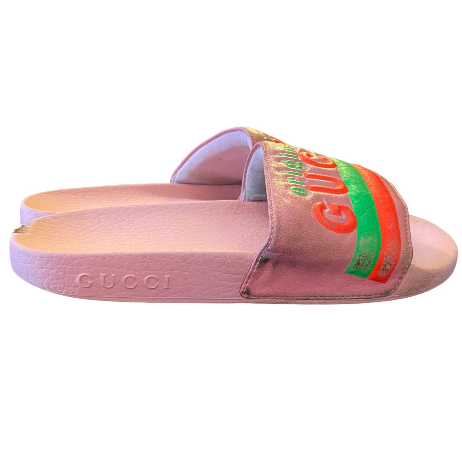 Pink Gucci slide sandal with colorful logo on a white background with shown dirt and issues