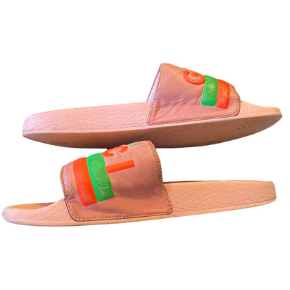Pair of pink slides with colorful straps on a white background on their side 2