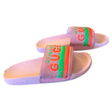 Pink slide sandals with colorful Gucci logo on a white background side view 1