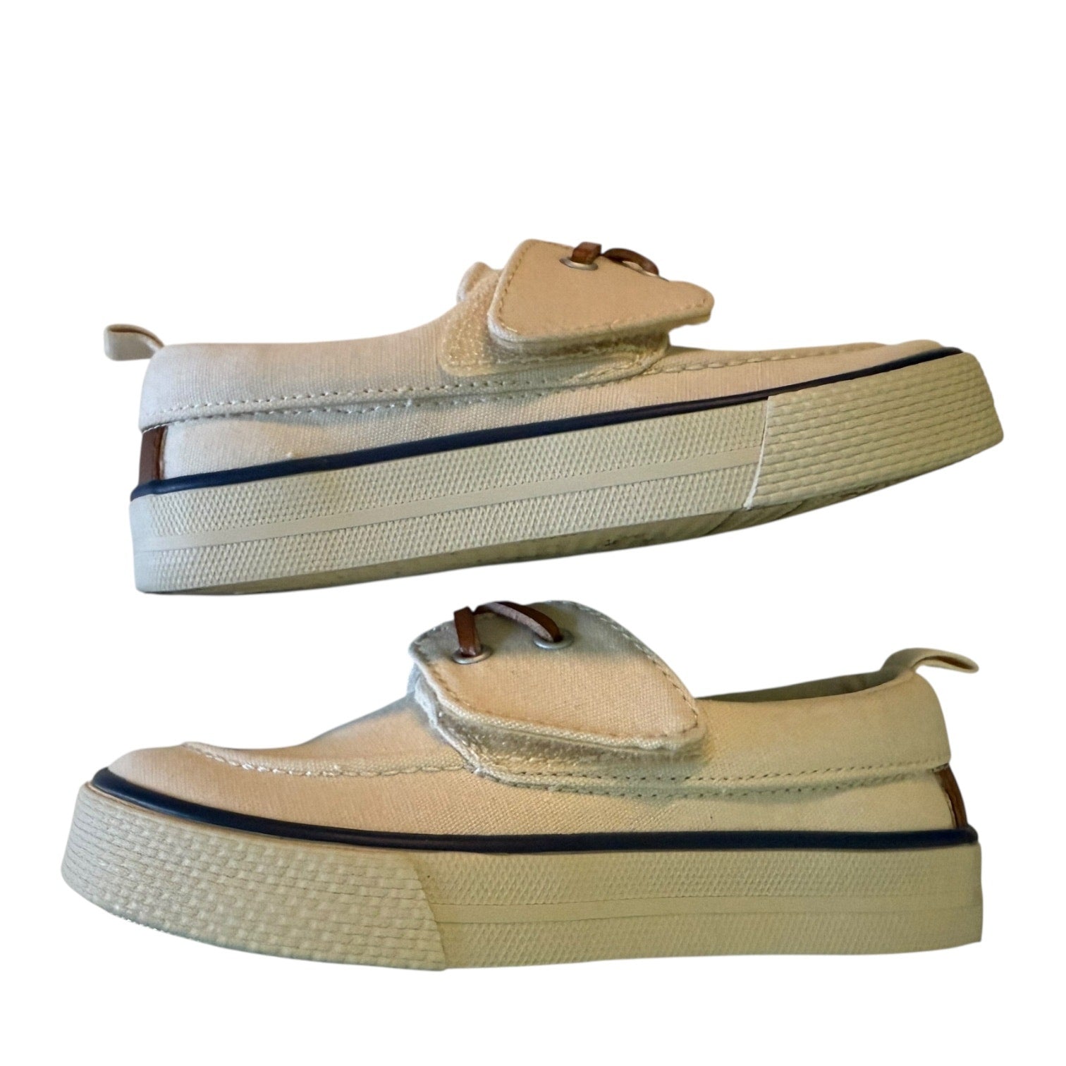 Side view of off white shoes with brown accents on a white background