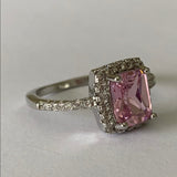 Front side of Ring with a pink gemstone and diamond accents on a light gray background