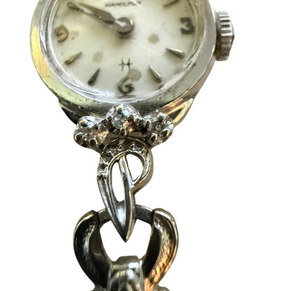 Silver watch with decorative band on a white background