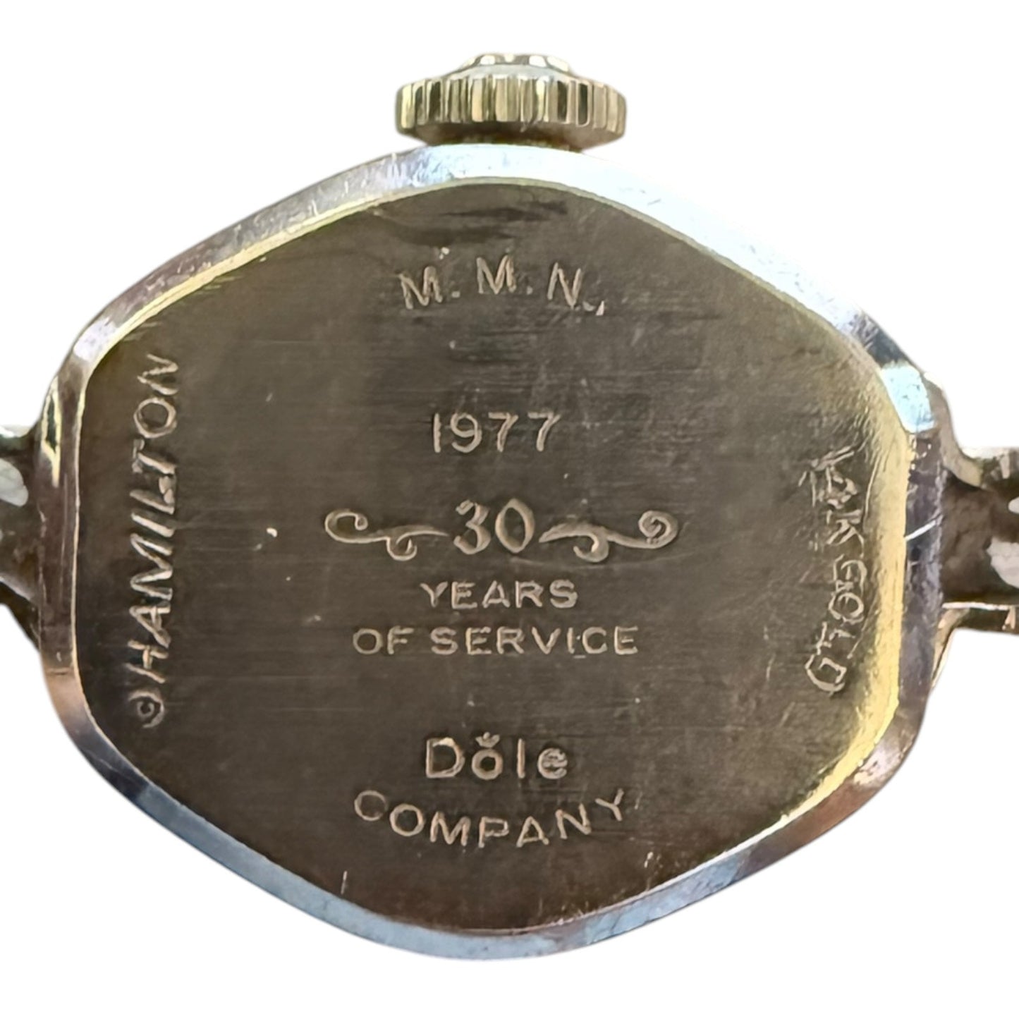 Back of a watch with engraved text celebrating 30 years of service at Dole Company in 1977.