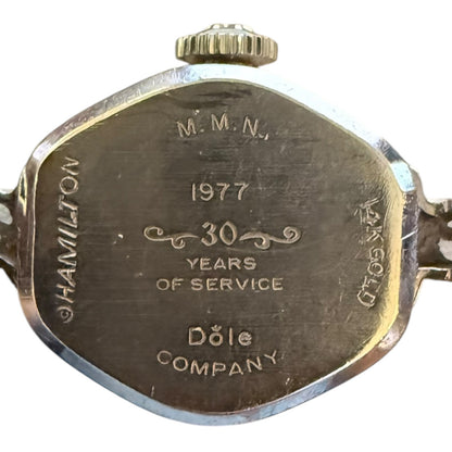 Back of a watch with engraved text celebrating 30 years of service at Dole Company in 1977.
