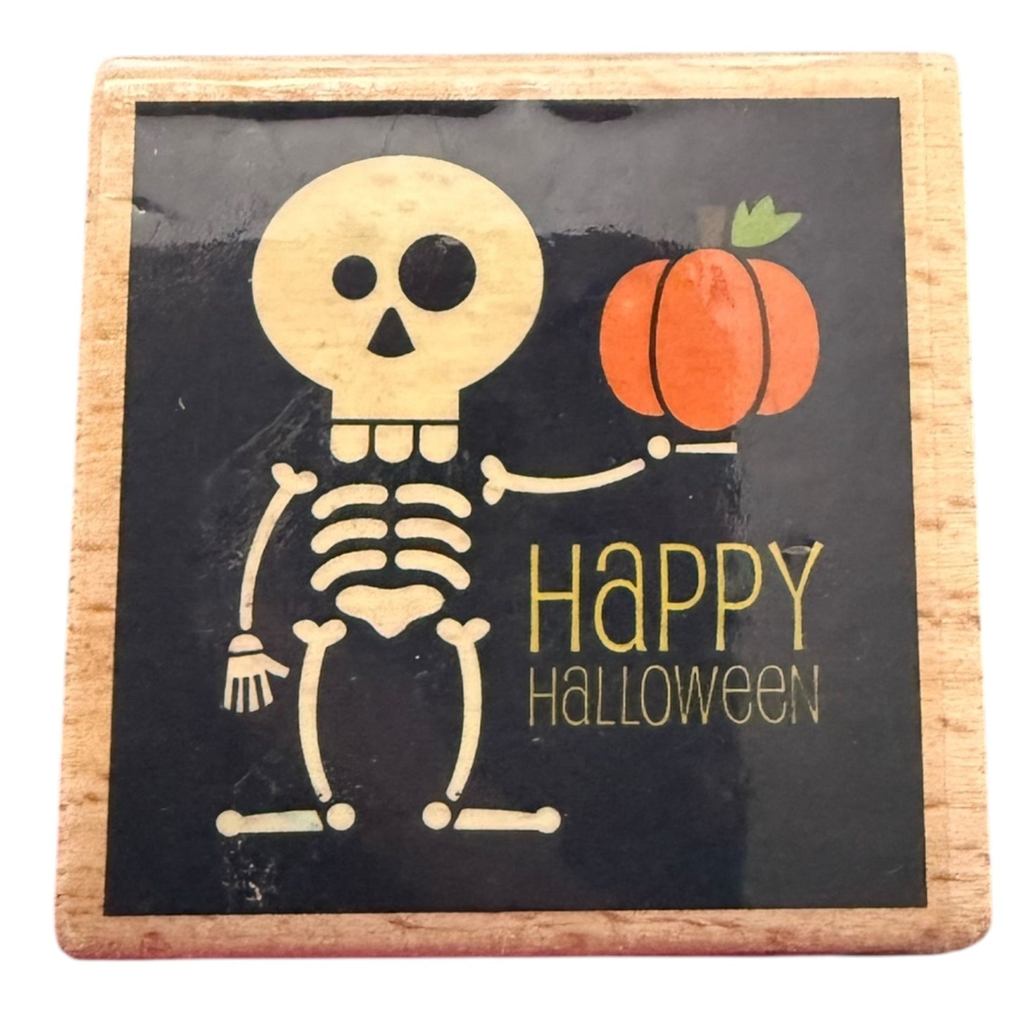 Halloween-themed coaster with skeleton and pumpkin design on a black background