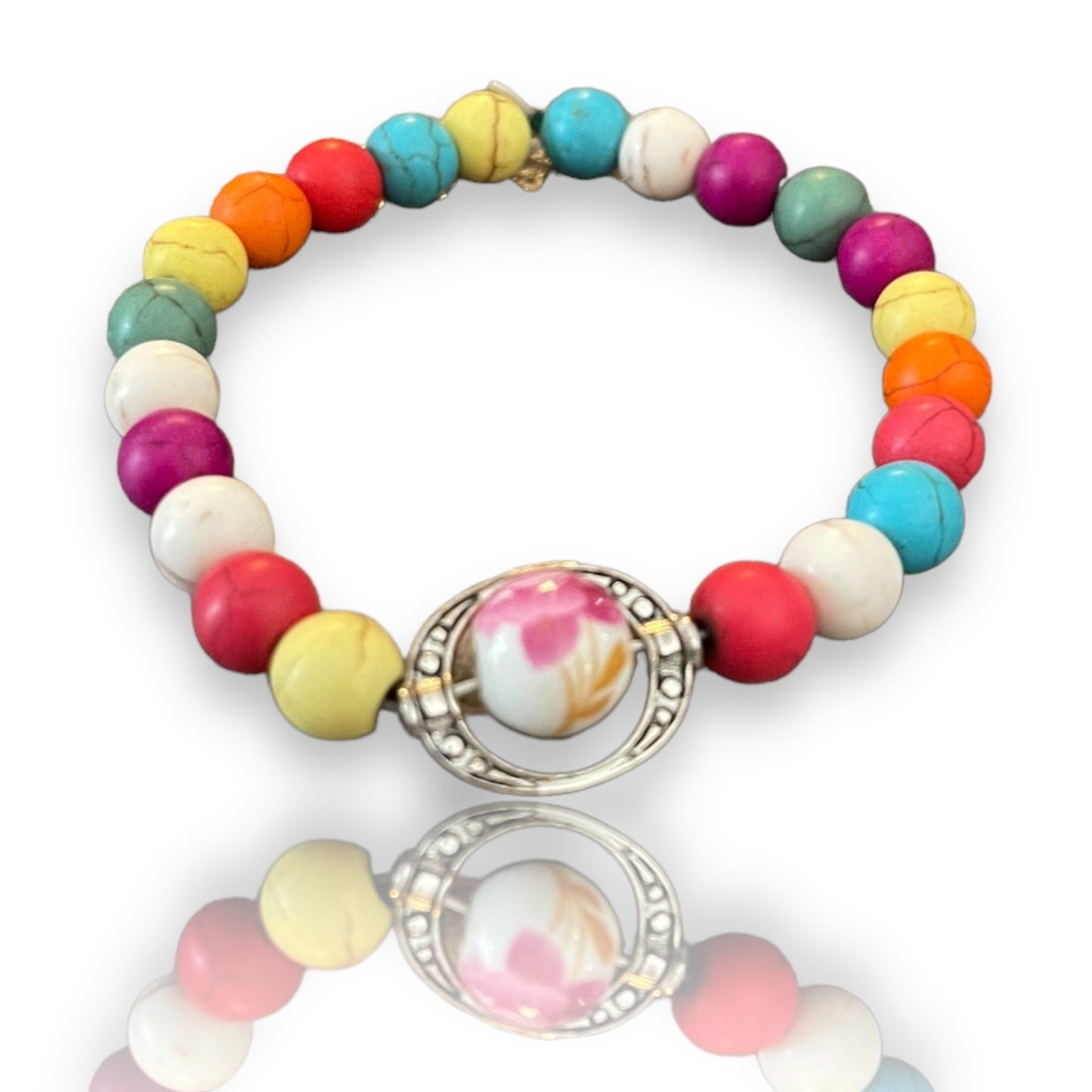 Colorful beaded bracelet with a silver charm on a white background