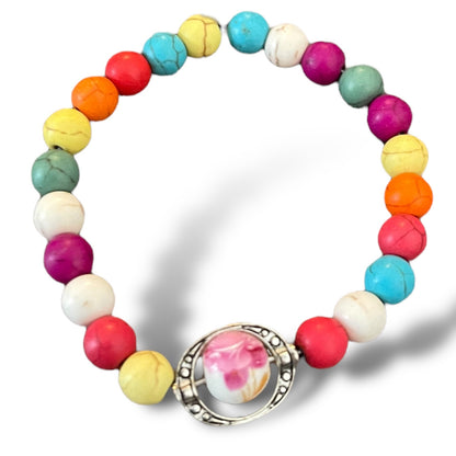 Colorful beaded bracelet with a charm on a white background