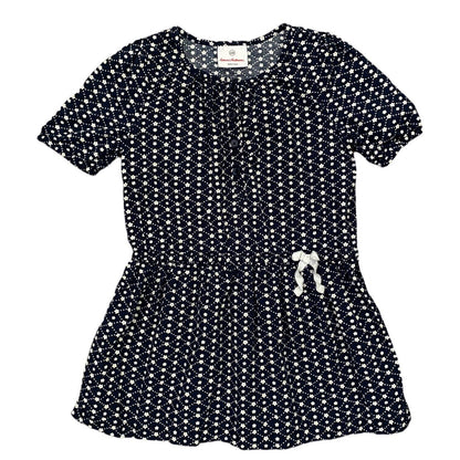 A short-sleeve peplum-style dress with an allover white floral print on a dark navy background, featuring a gathered waist and a small white bow detail on the front.
