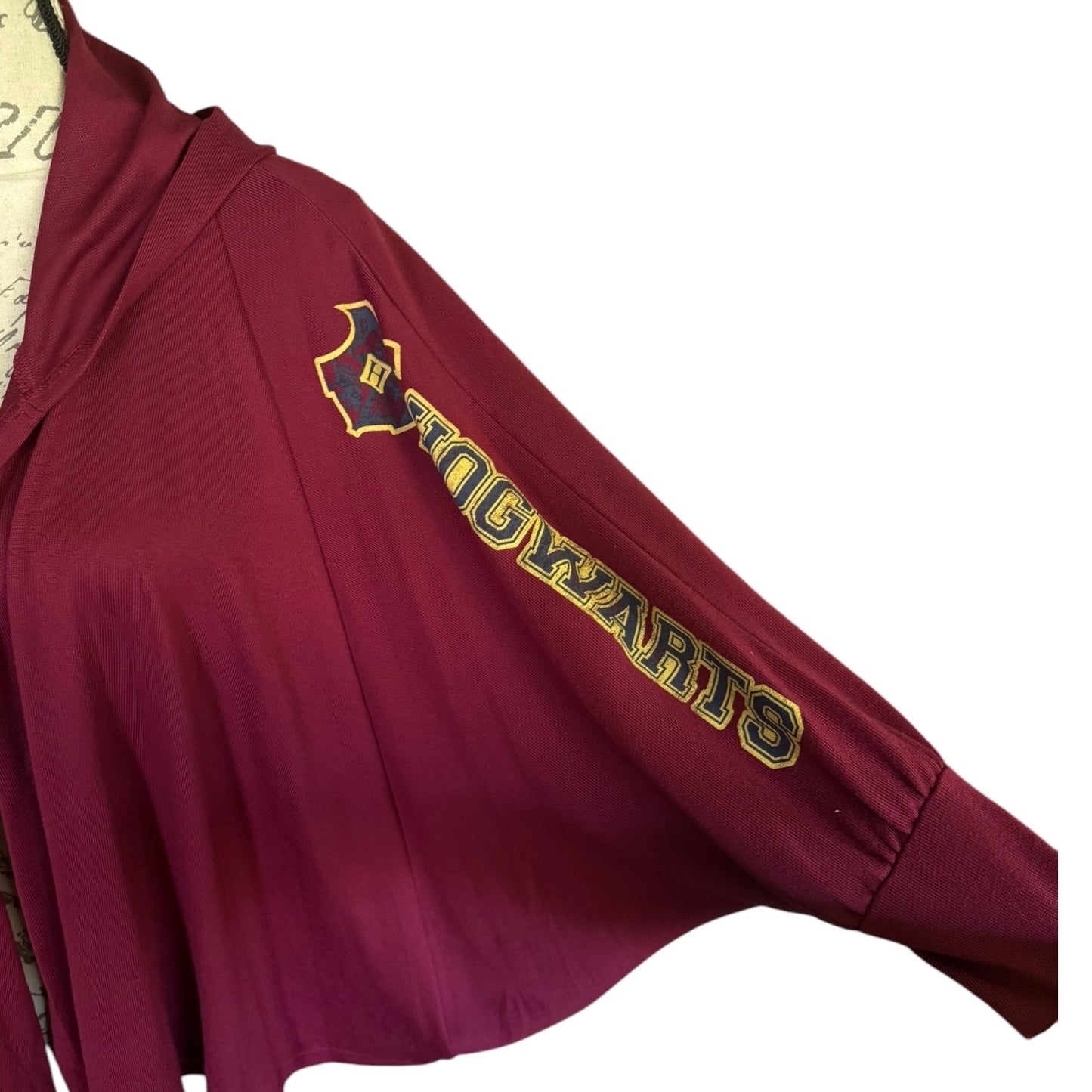 A close-up of a sleeve with 'HOGWARTS' and a emblem  on the sleeve, shown against a white background.