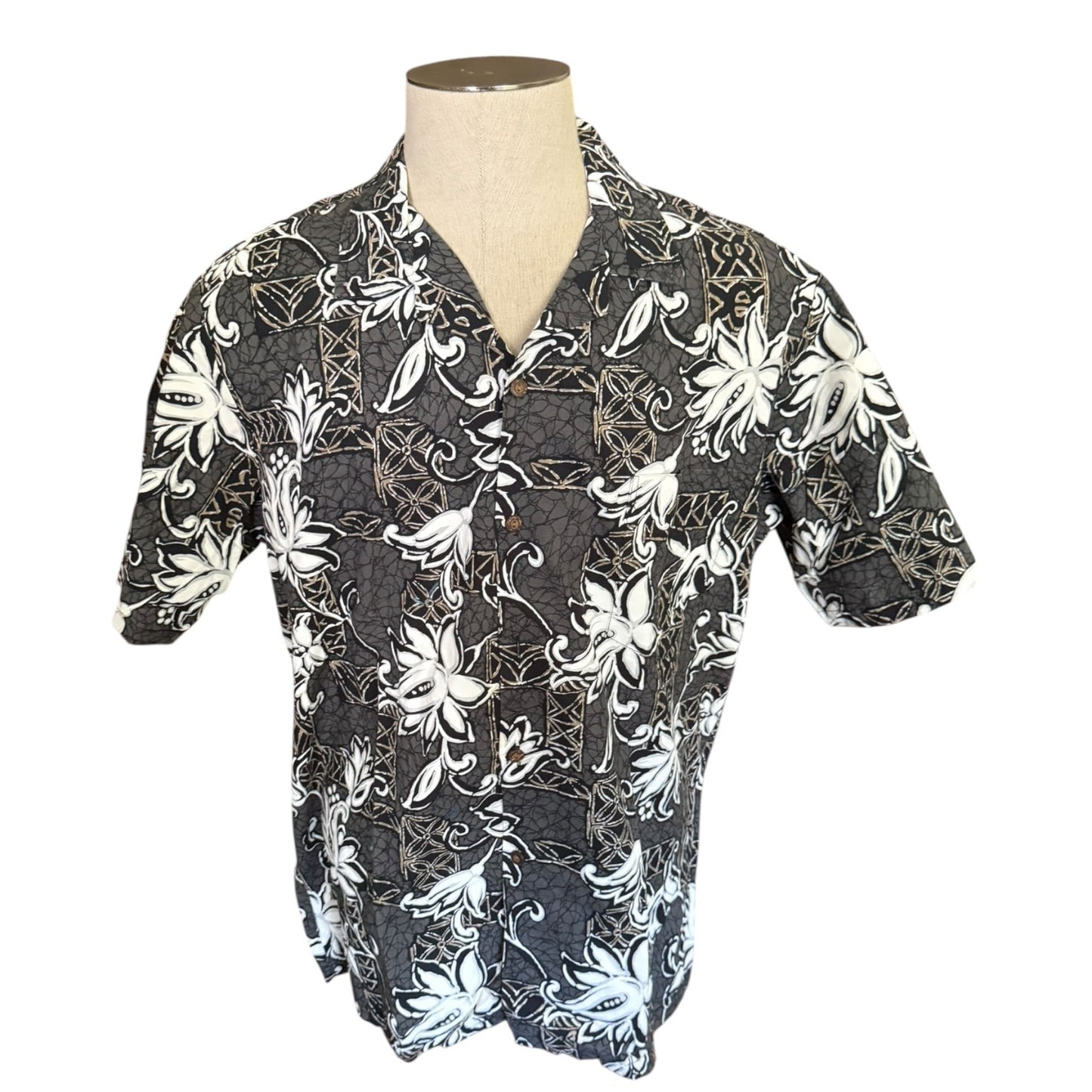 A men's short-sleeve button-up shirt displayed on a mannequin torso. The shirt features a  gray base with a bold white floral and vine pattern.