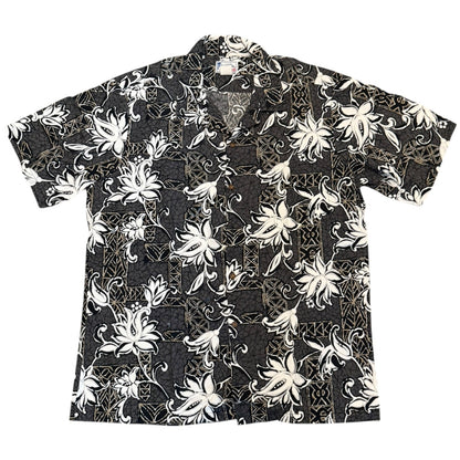 A short-sleeve button-up aloha shirt with a gray base featuring a white floral and vine pattern, laid flat against a white background.