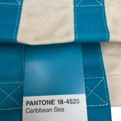 Close-up of a fabric swatch with a Pantone 18-4525 Caribbean Sea color swatch.