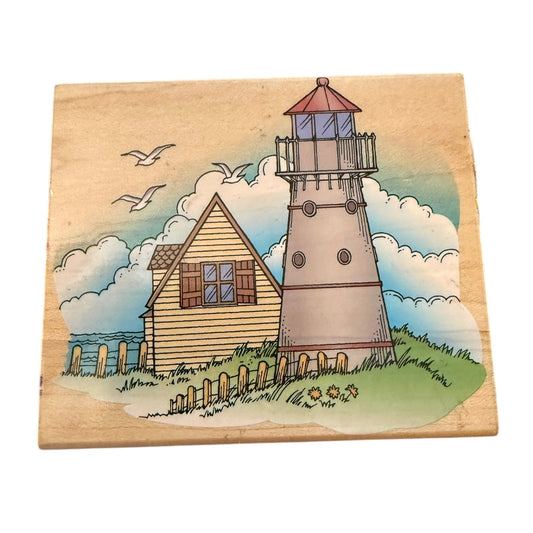 Wooden block with a lighthouse and house illustration on a white background