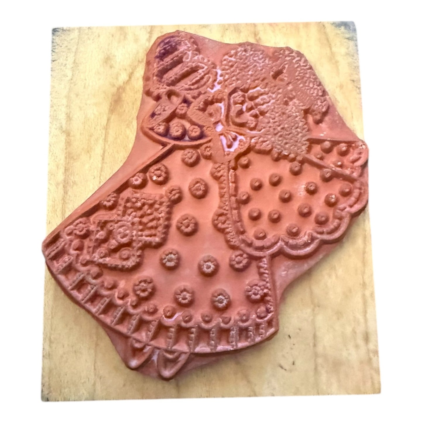 Decorative red stamp on a wooden block with intricate patterns