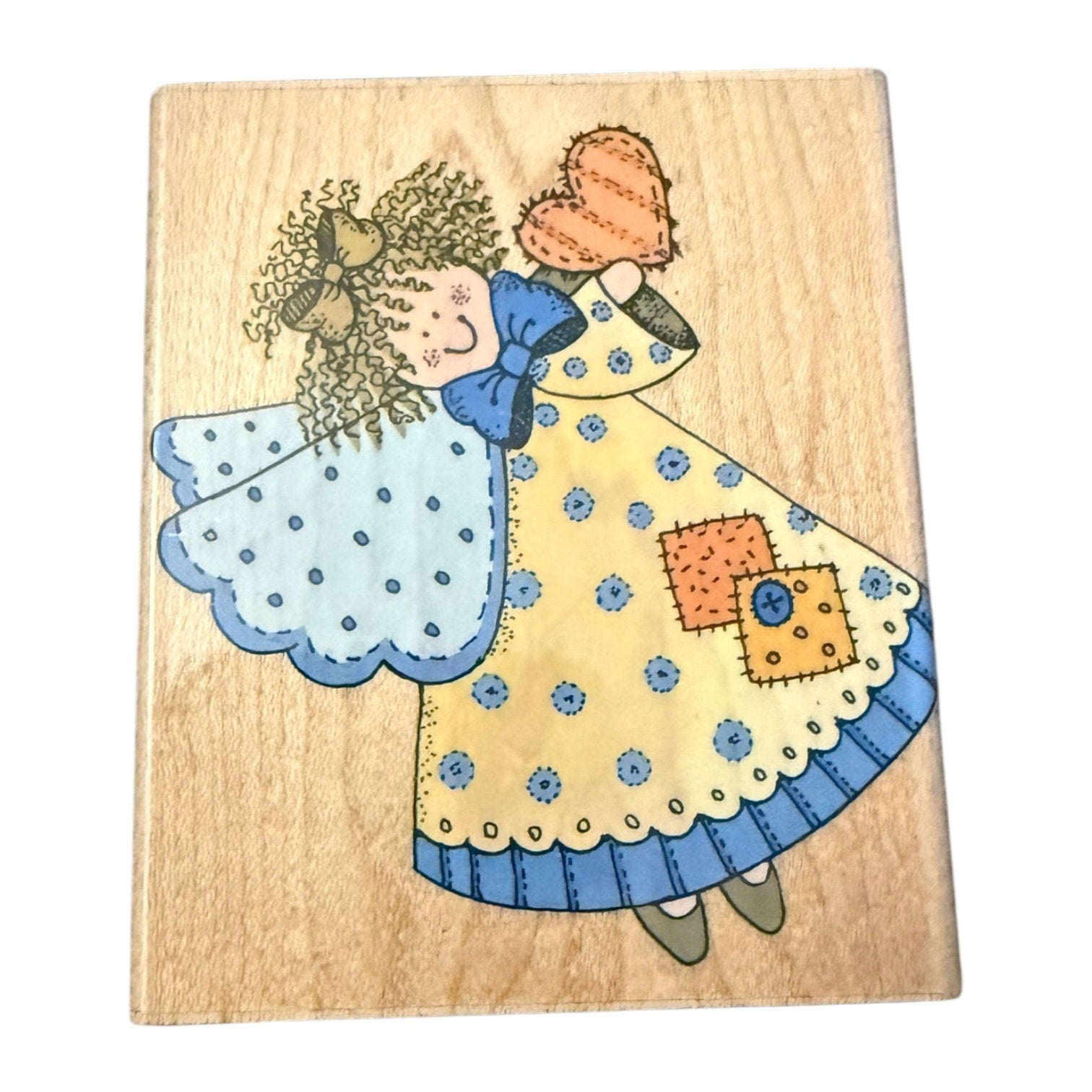 Wooden block with a colorful illustration of an angel in a dress on a white background