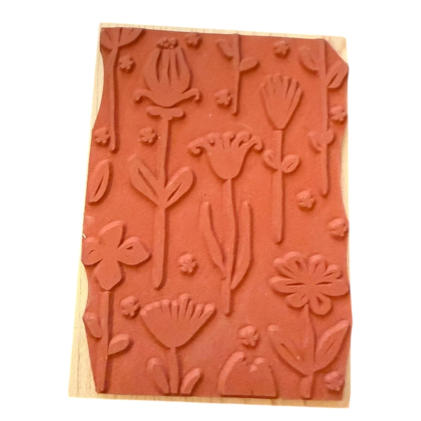 Wooden stamp block with floral embossing on a white background