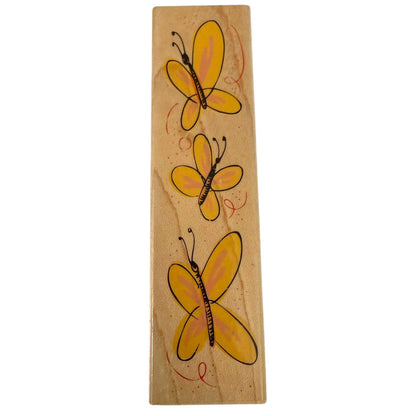 Wooden stamp with three yellow butterflies on a white background