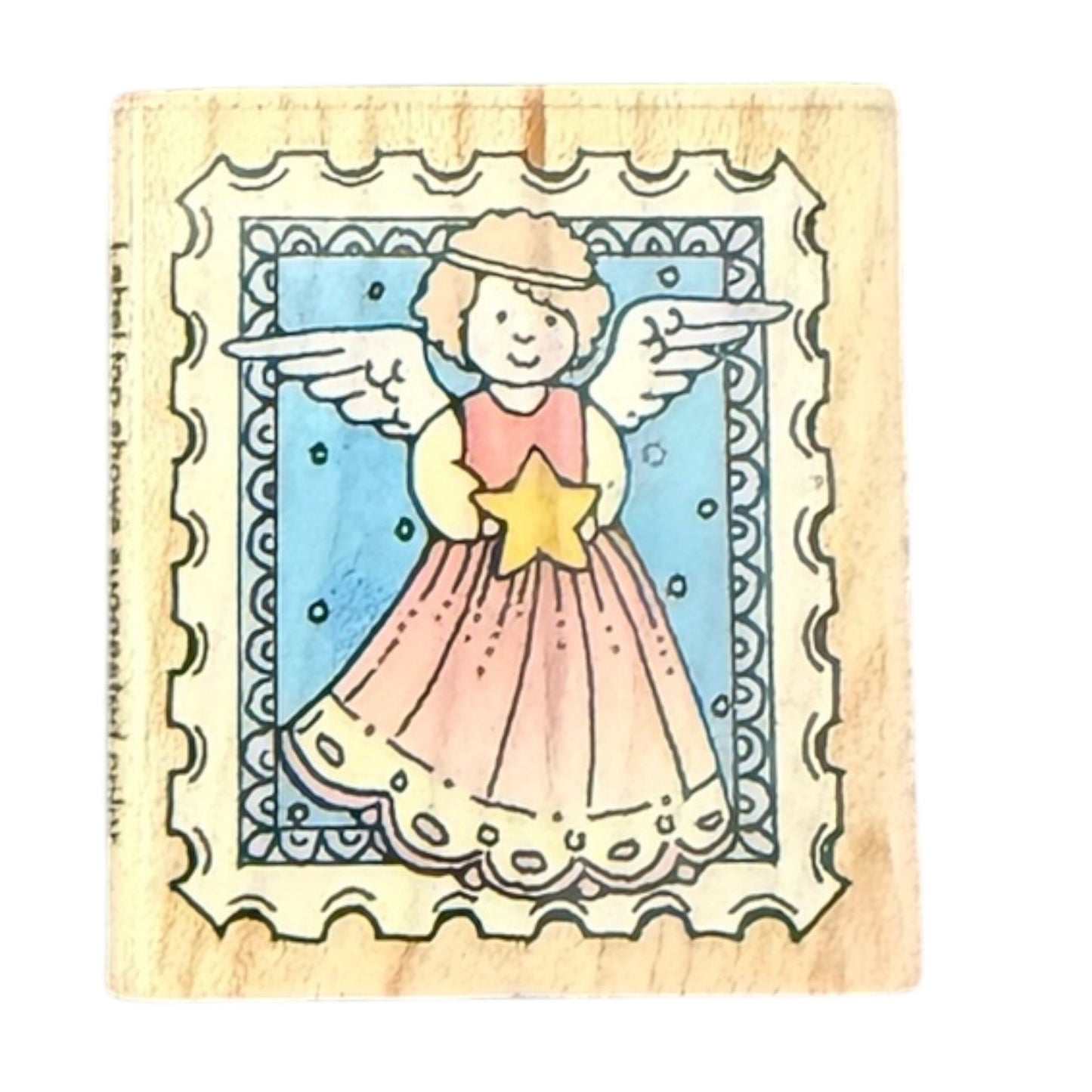 Wooden stamp with a cartoon angel holding a star, framed by decorative patterns.