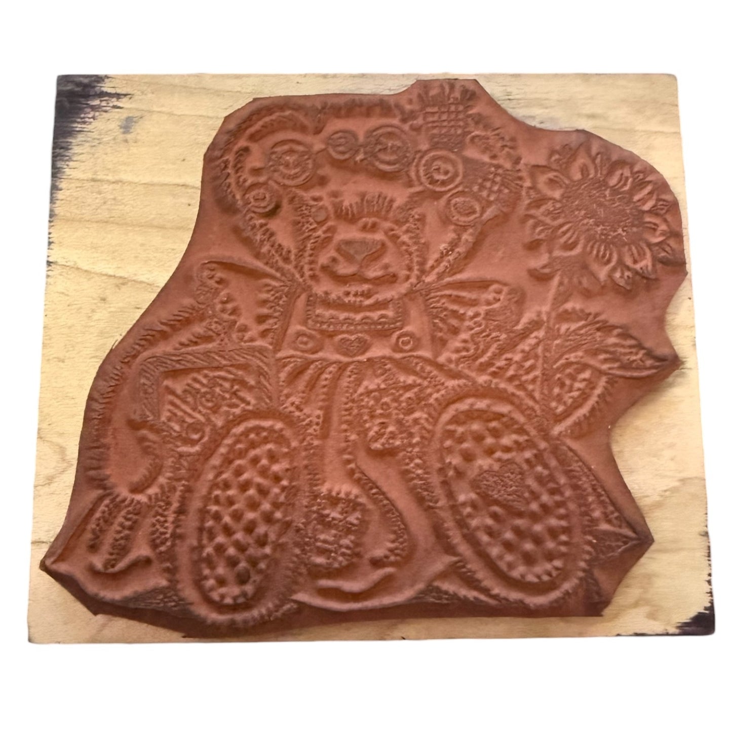 Wooden stamp with a bear and floral design on a wooden block