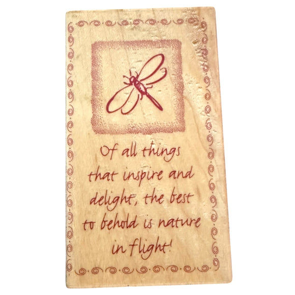 Decorative stamp with a dragonfly illustration and text on a beige background block