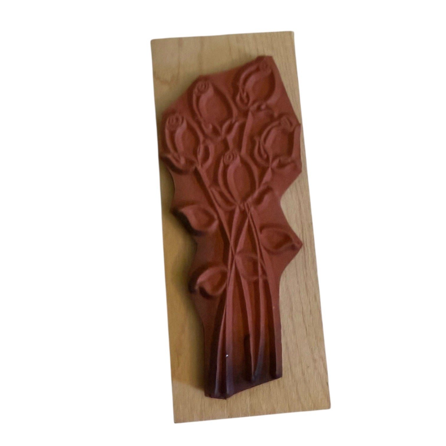 Decorative wooden stamp with a red design on a white background