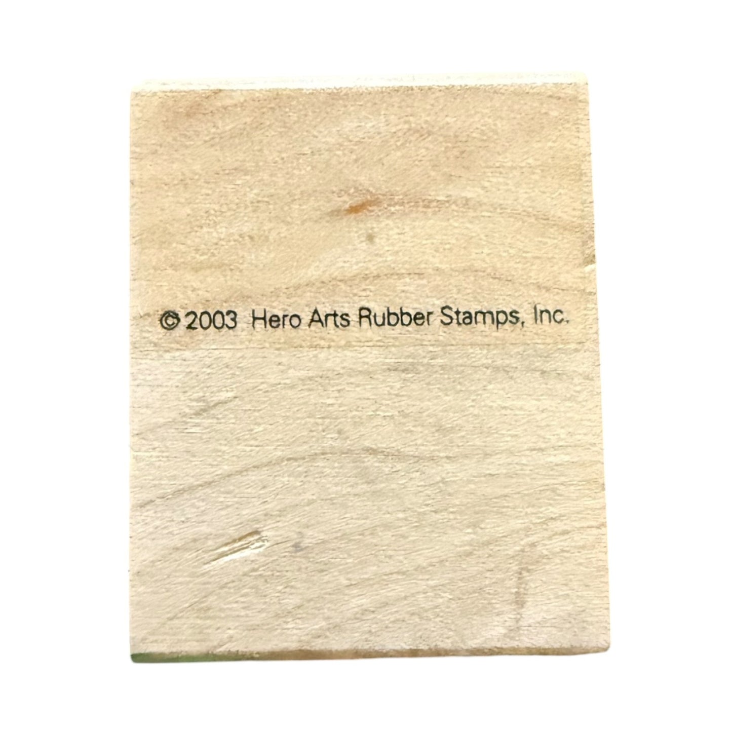 A wooden block light beige rubber stamp block with black printed copyright text reading '© 2003 Hero Arts Rubber Stamps, Inc.' on a plain white background.