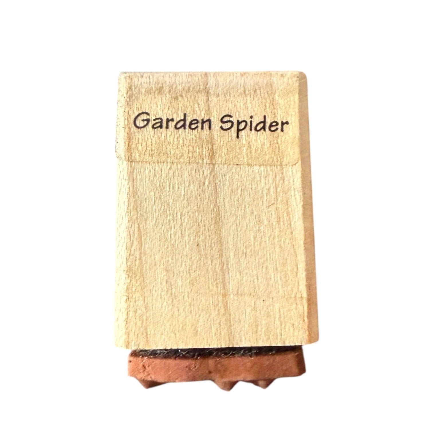 Wooden stamp with 'Garden Spider' text on a white background