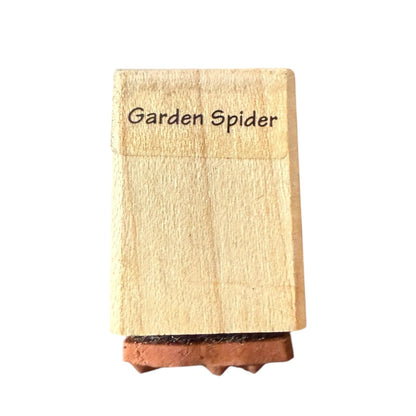 Wooden stamp with 'Garden Spider' text on a white background