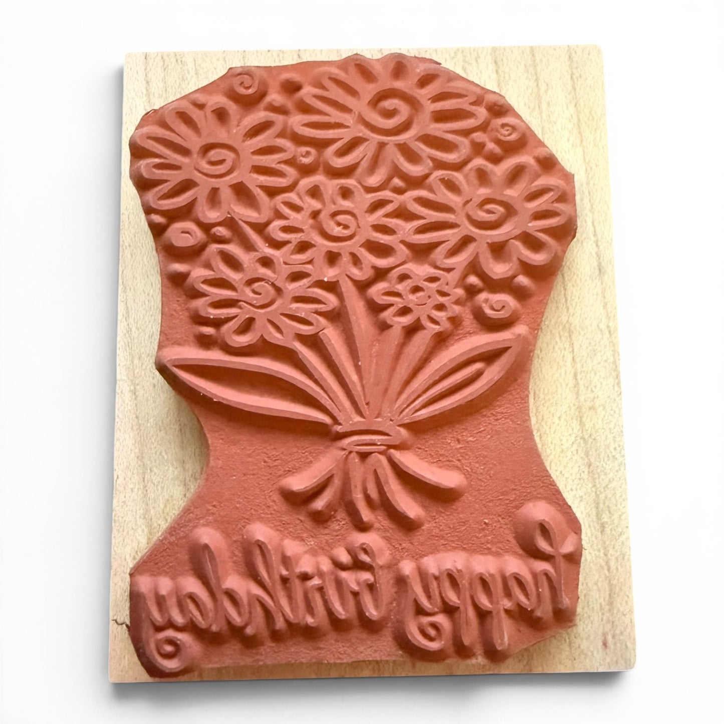 Wooden stamp with floral design and text on a wooden block