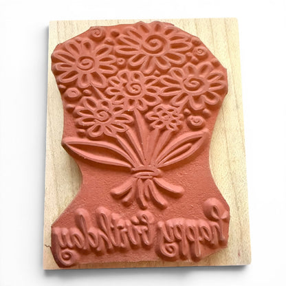 Wooden stamp with floral design and text on a wooden block