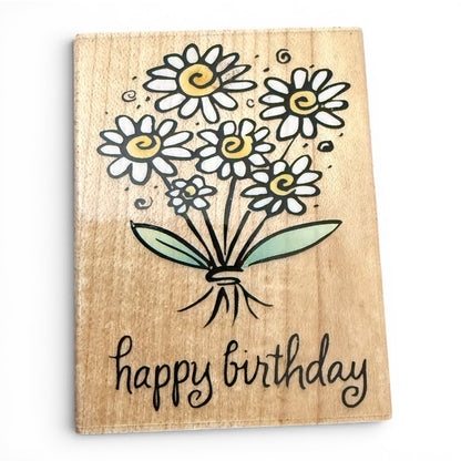 Wooden stamp with a bouquet of flowers and 'happy birthday' text on a white background