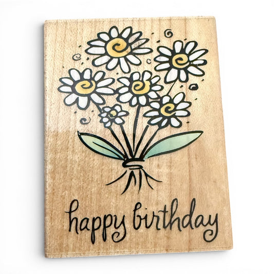 Wooden stamp with a bouquet of flowers and 'happy birthday' text on a white background