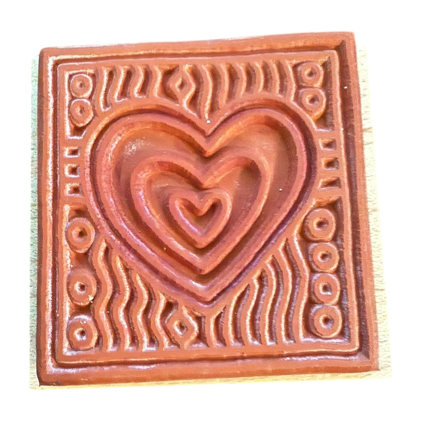 Rubber stamp with a heart design on a white background