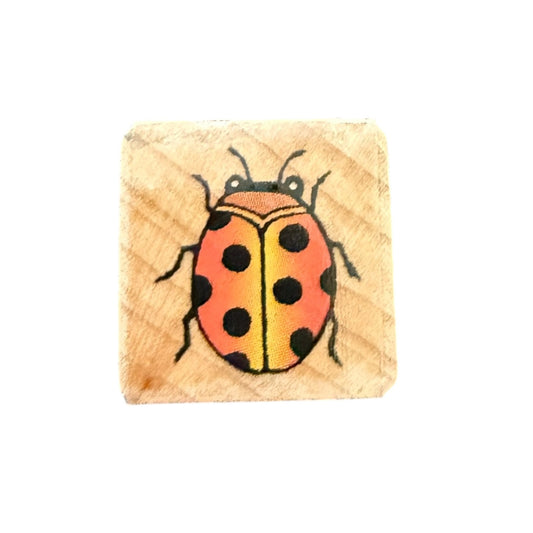 Wooden block with a ladybug design on a white background