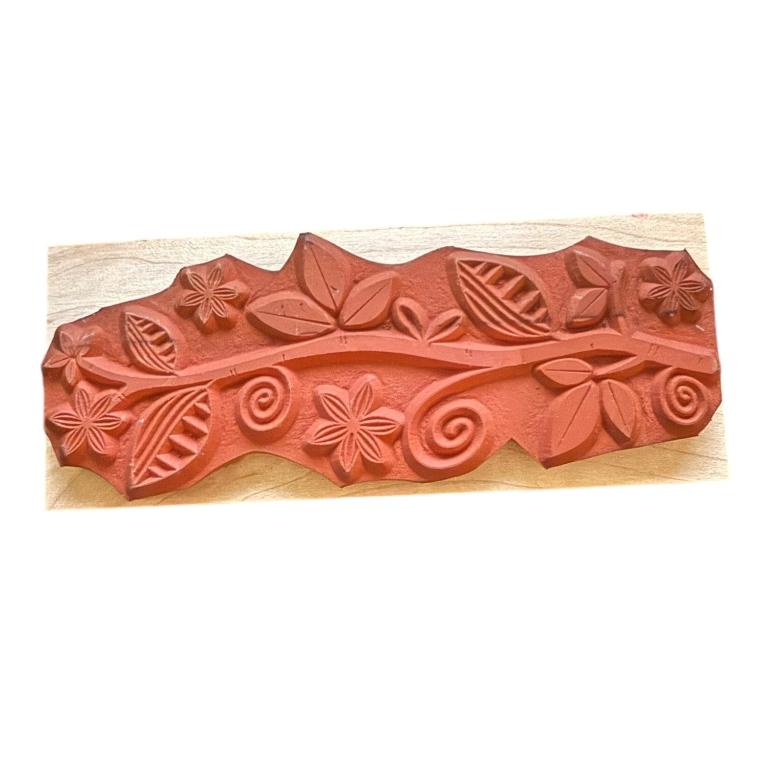 Decorative stamp with floral and leaf patterns on a wooden block