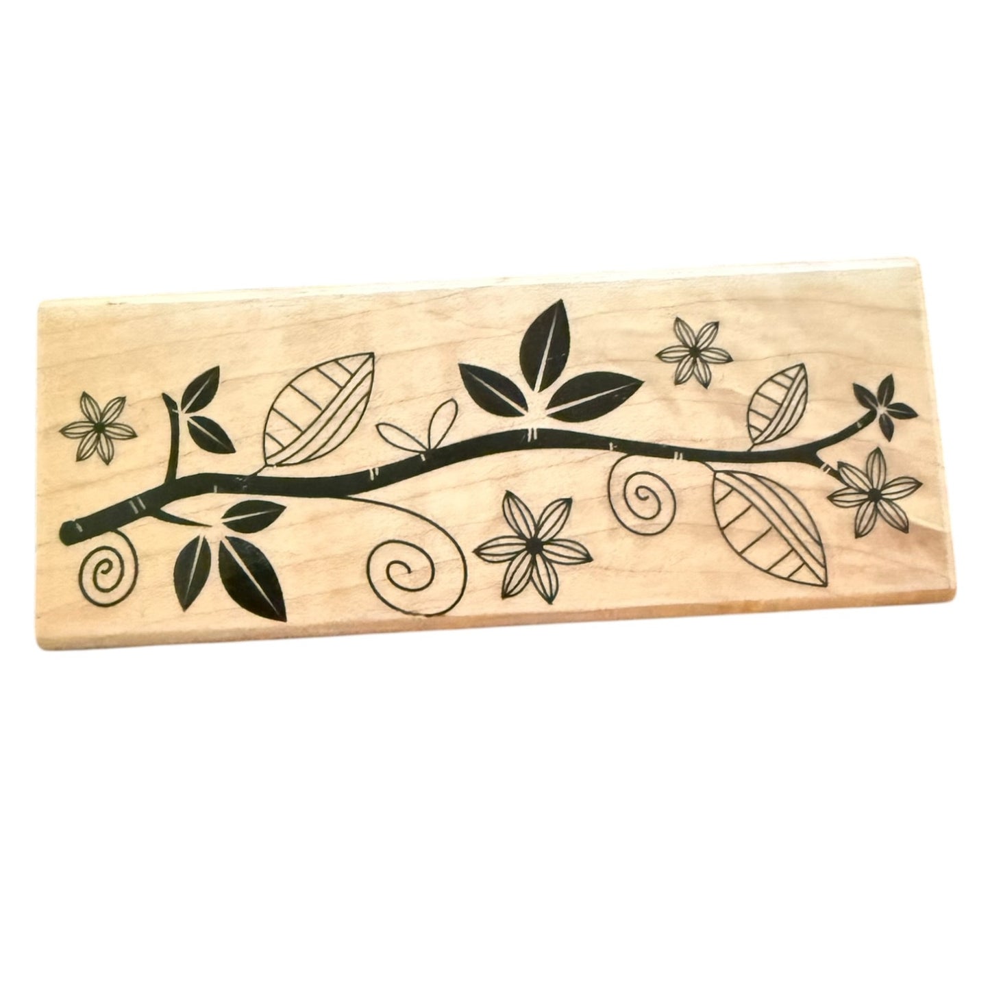 Wooden stamp with black floral and leaf design on a white background