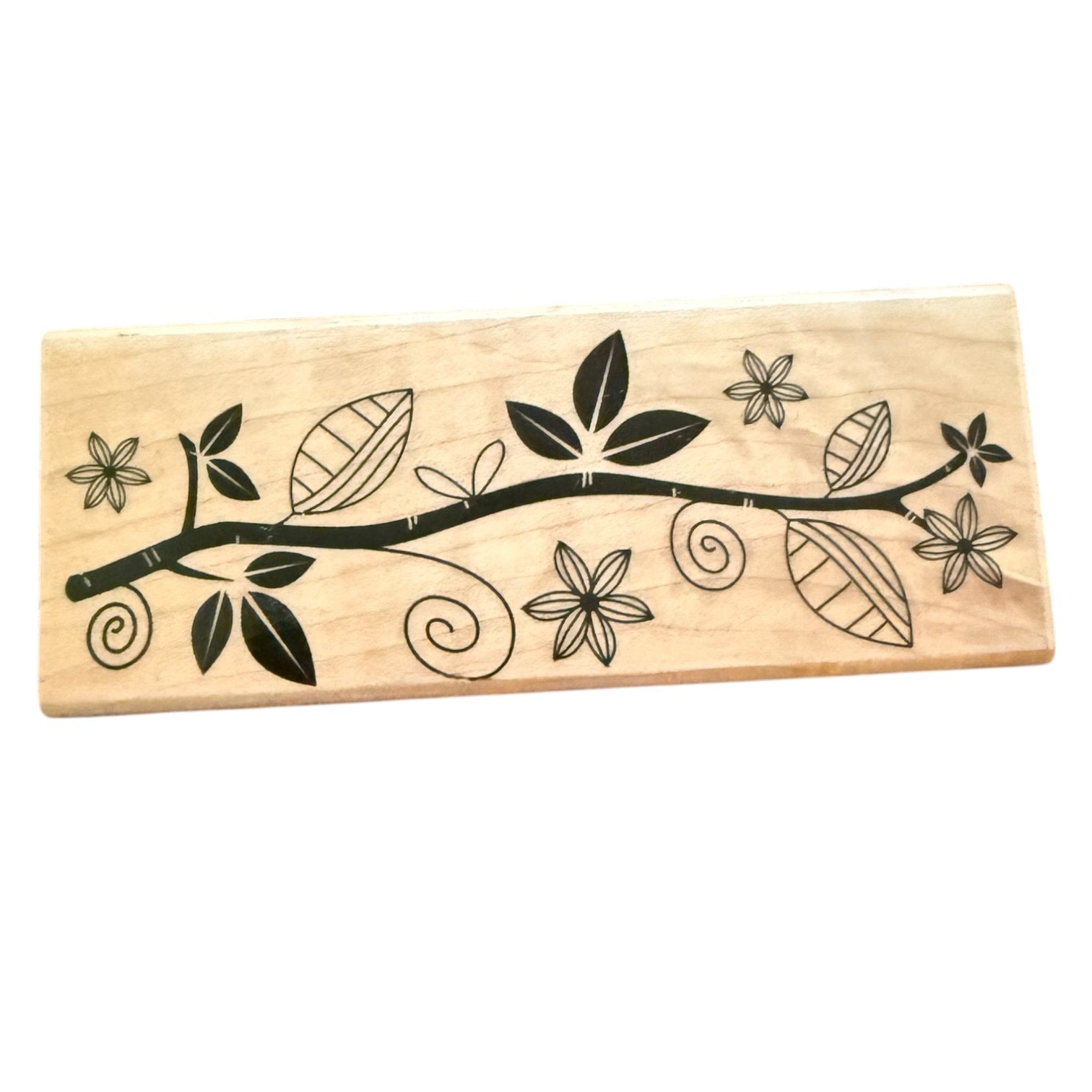 Wooden stamp with black floral and leaf design on a white background