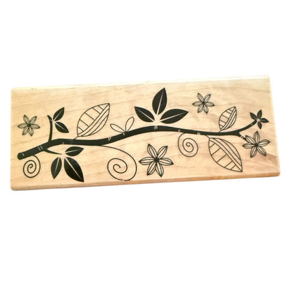 Wooden stamp with black floral and leaf design on a white background