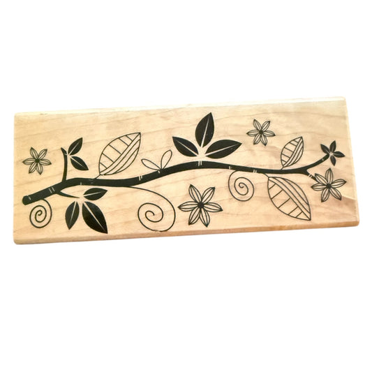 Wooden stamp with black floral and leaf design on a white background