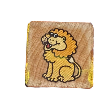 Smiling lion stamp on a wood block with yellow stains on a white background. 