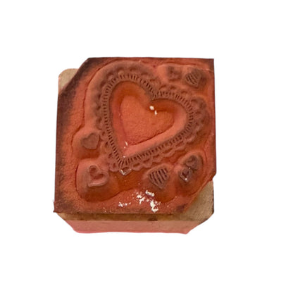 Heart rubber stamp showing stain on a wood block with a white background. 