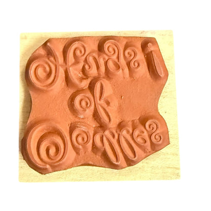 Rubber stamp with decorative design on a wooden block