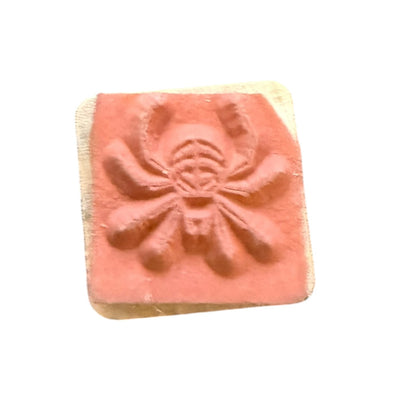 Rubber stamp with a spider design on a white background