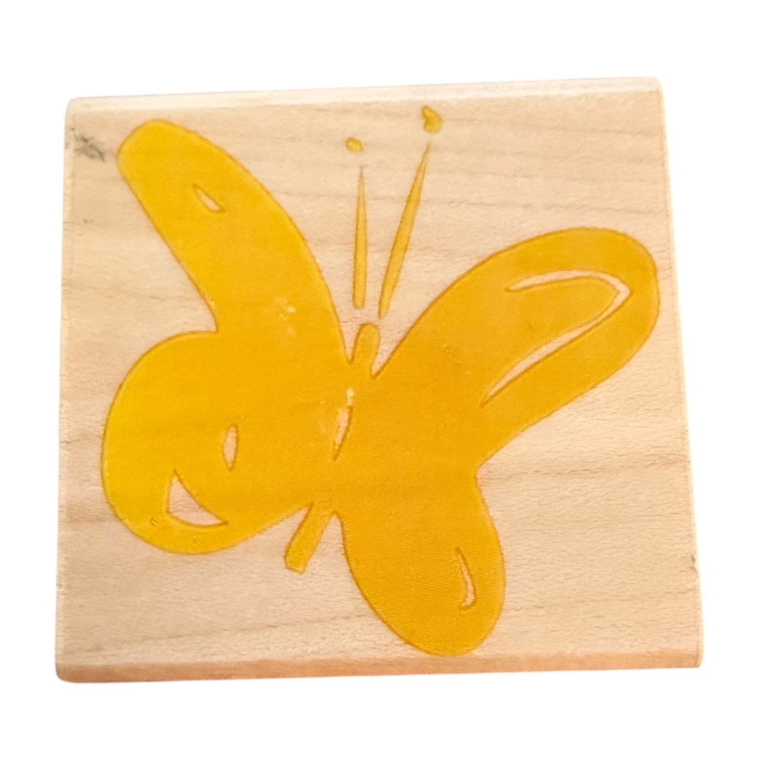 Wooden stamp with a yellow butterfly design on a white background