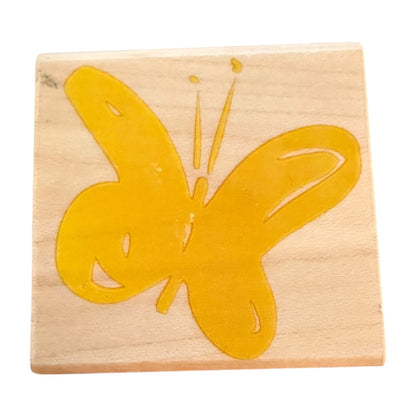 Wooden stamp with a yellow butterfly design on a white background
